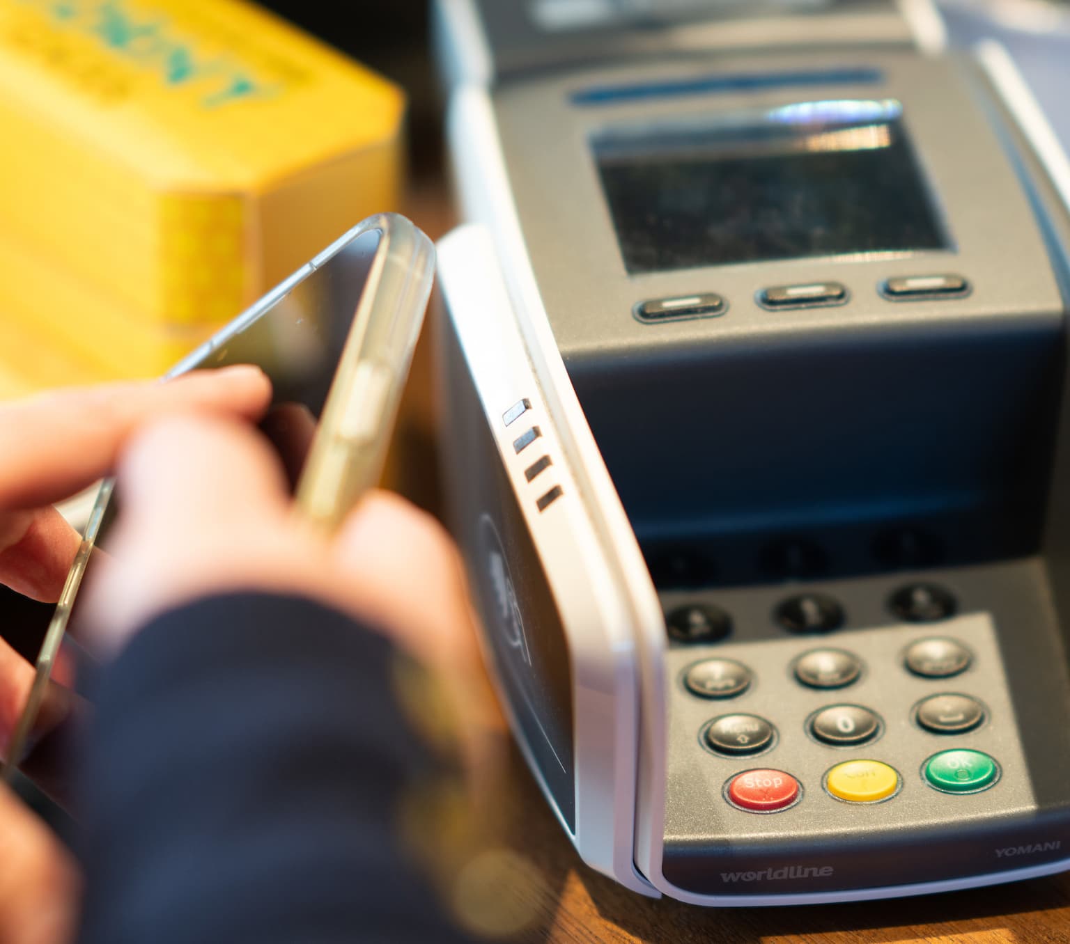 Person using mobile phone to pay for items at a supermarket.