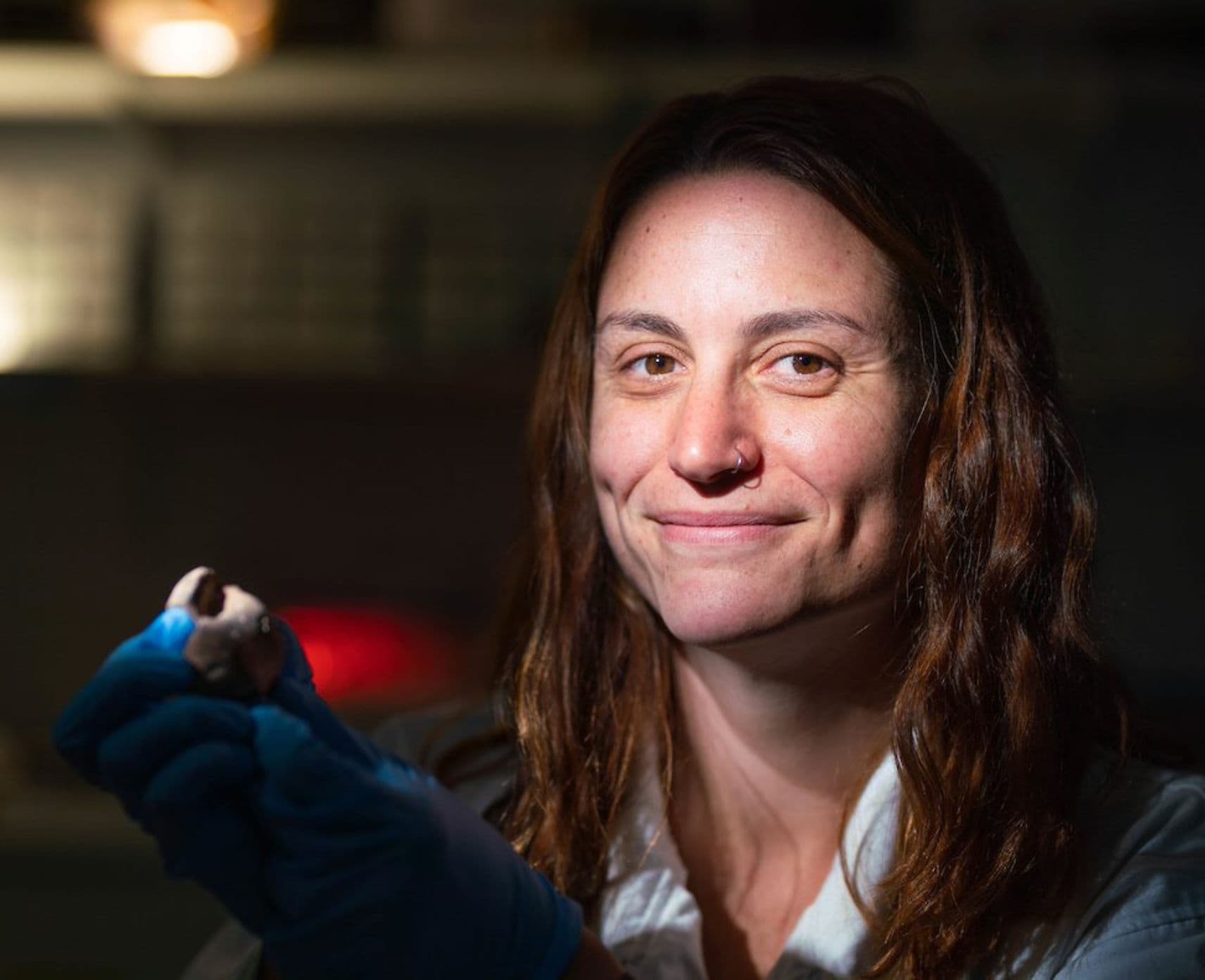 Close up of a female researcher holding a small object.