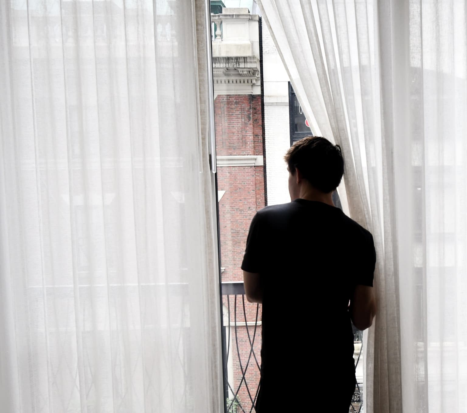 back of a man looking out a window