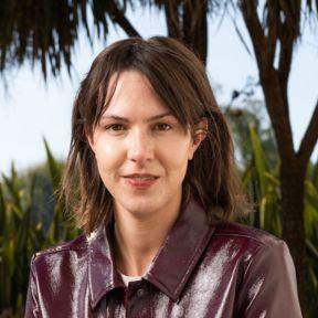 Hannah Dixon smiles at the camera. She has brown hair and wears a burgundy jacket.