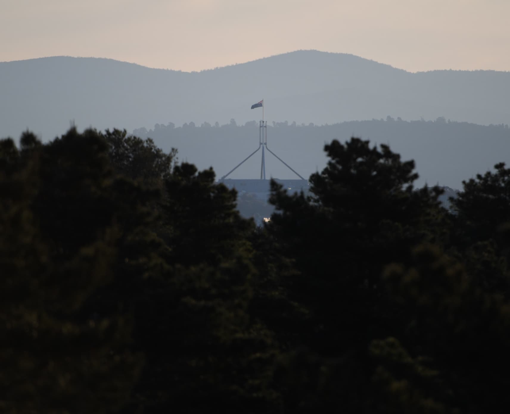 What is the state? Australia's Parliament House in the distance with trees in foreground.