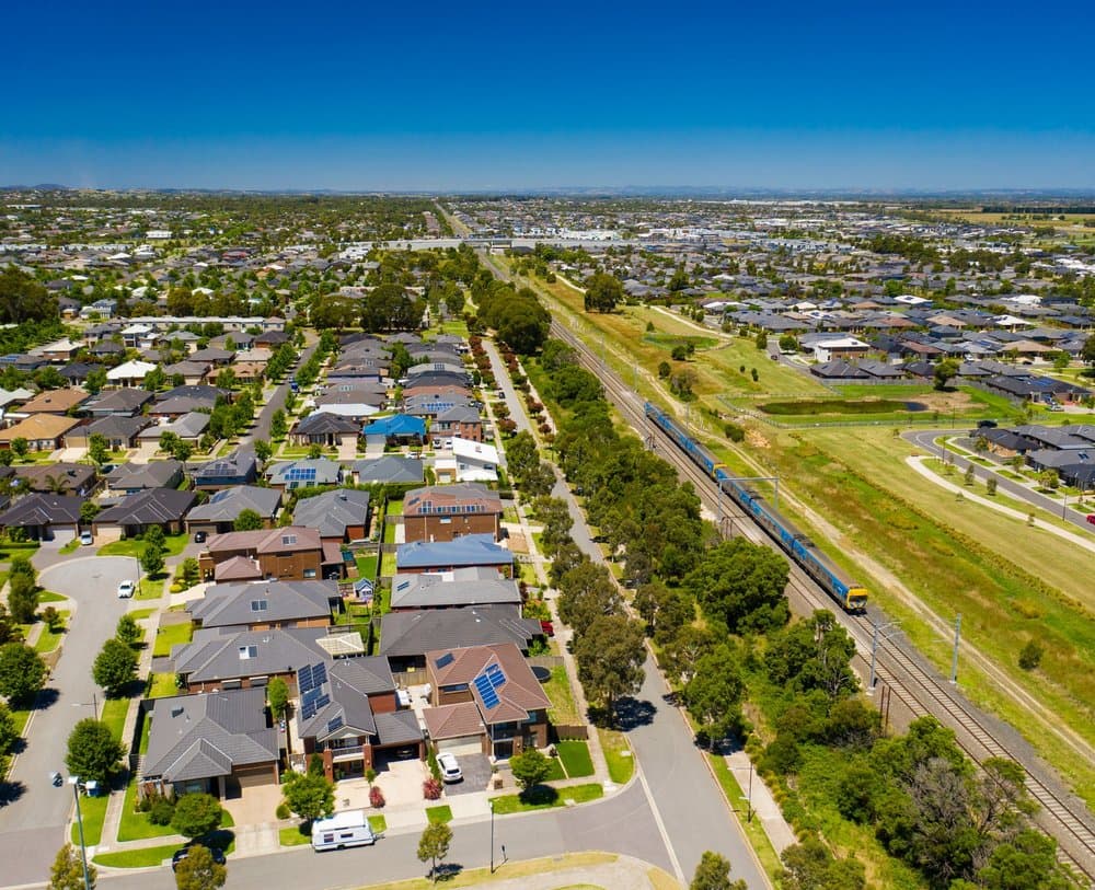 An aerial view of homes and a train track to the right of the photo