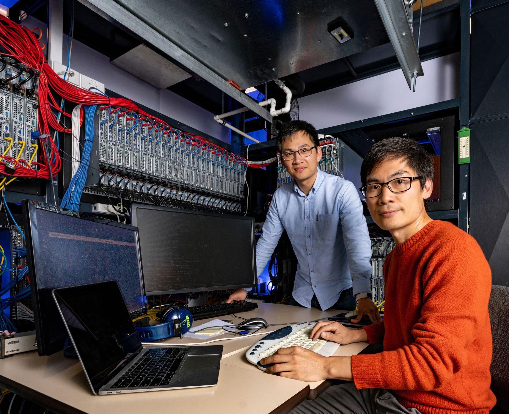 Two ANU scientists are in front of their computers and work space.