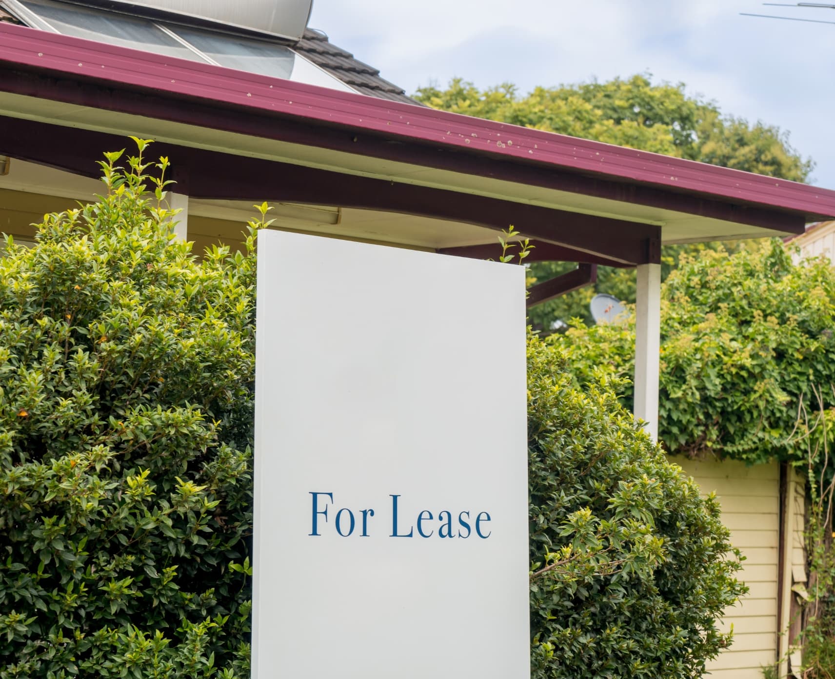 A 'For Lease' sign next to an Australian suburban home