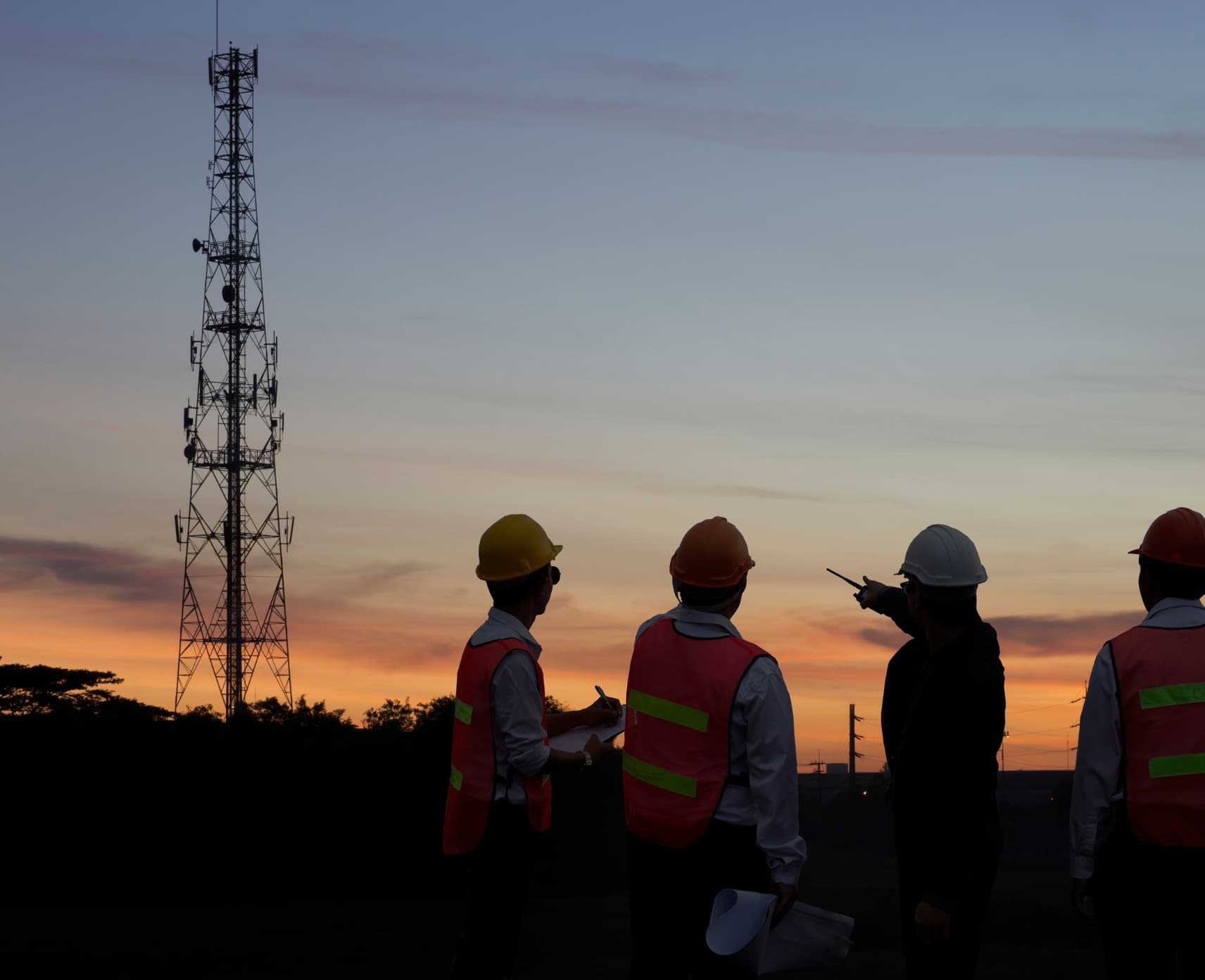 Three telecommunications engineers looking out at satellites