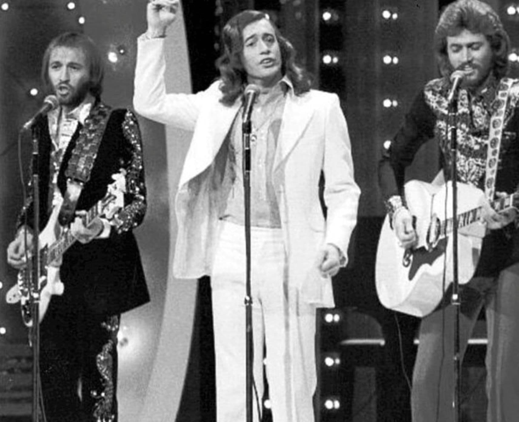 A black and white photo of the Bee Gees performing