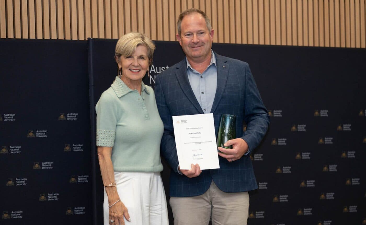Two people pose with an award