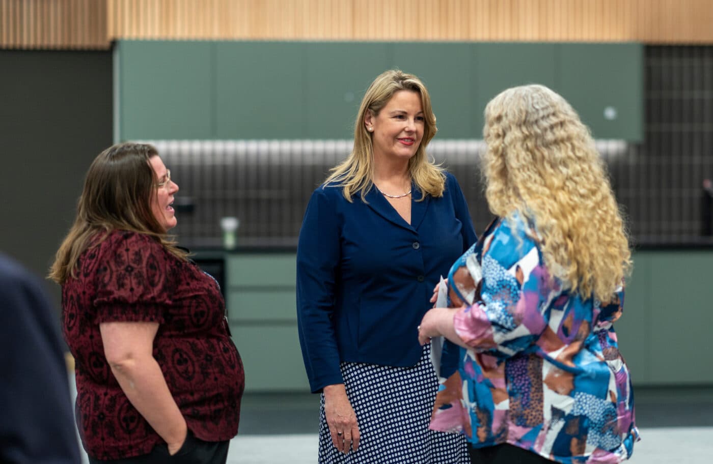 Three peopl informally speaking after an event