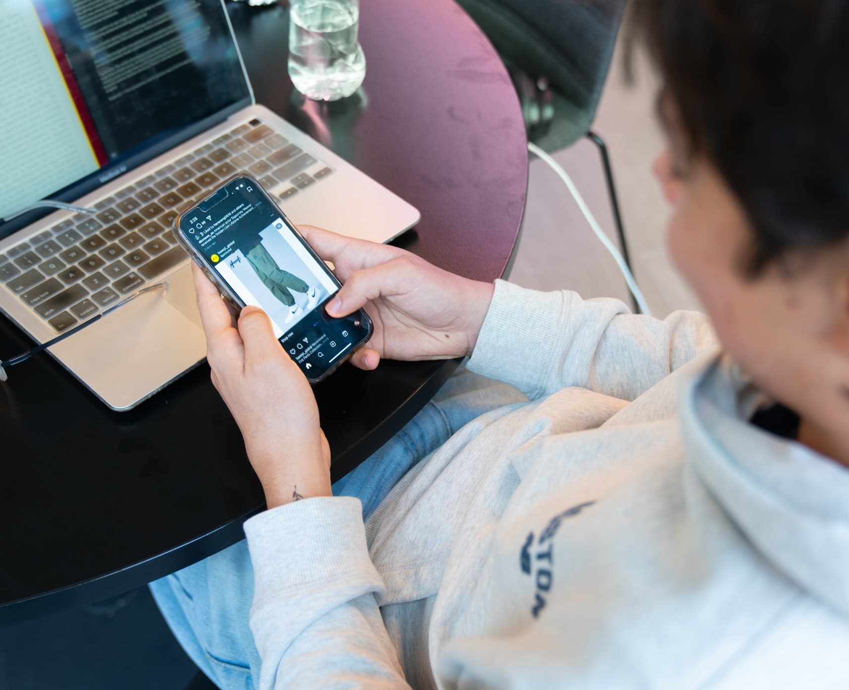 An unidentified man looking at the social media app Instagram on his phone.
