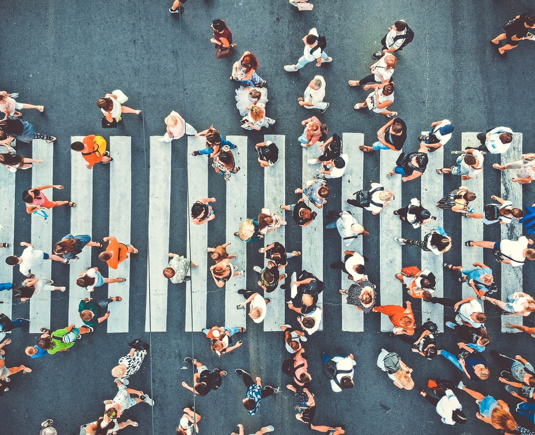 An aerial view of a group of people navigating a zebra crossing.