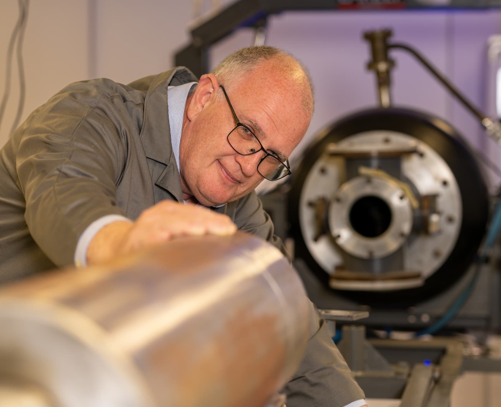 An engineer peers into a metal tube.
