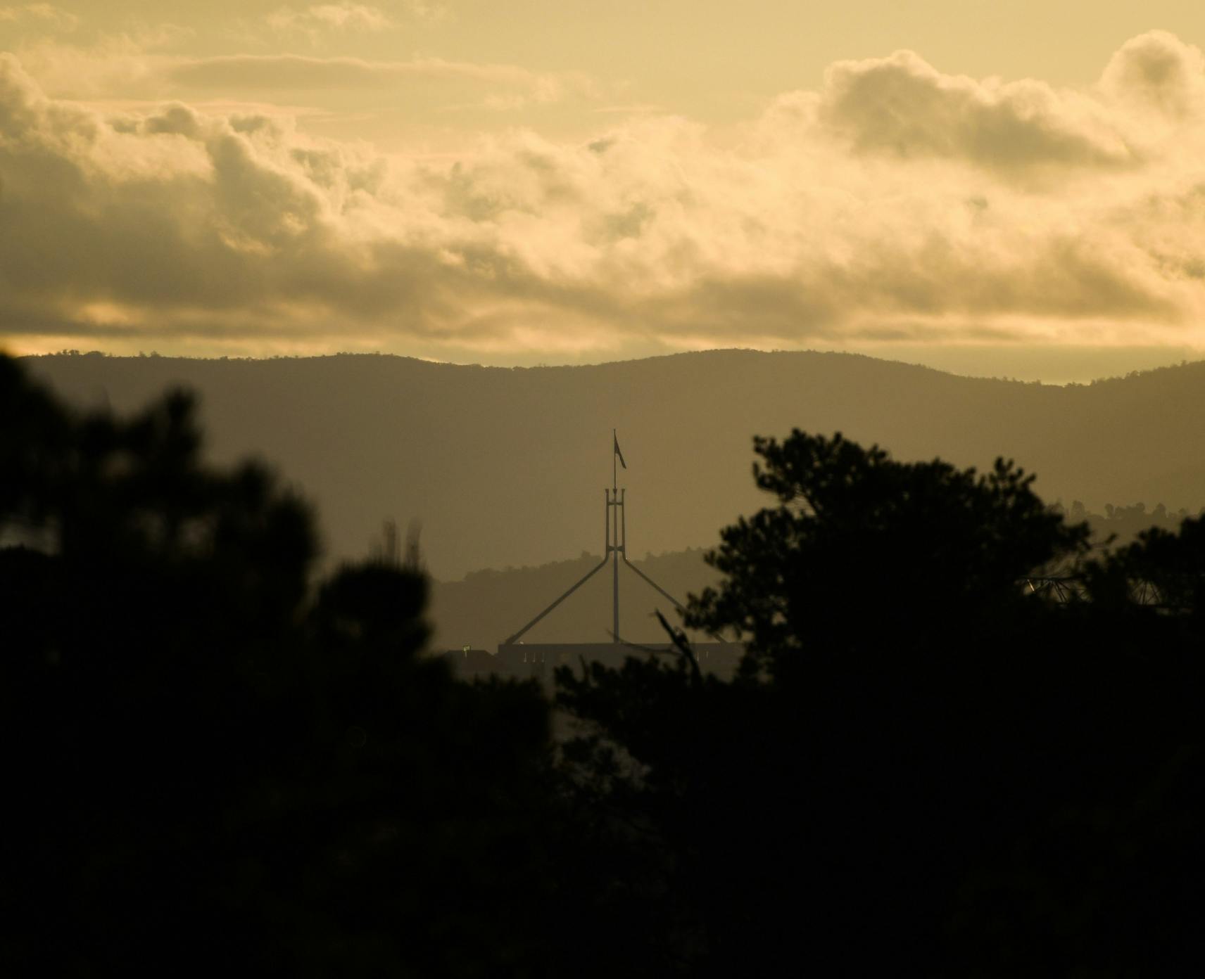 Hazy skies over Parliament House from semi rural land to the east of the Australian National University in Canberra