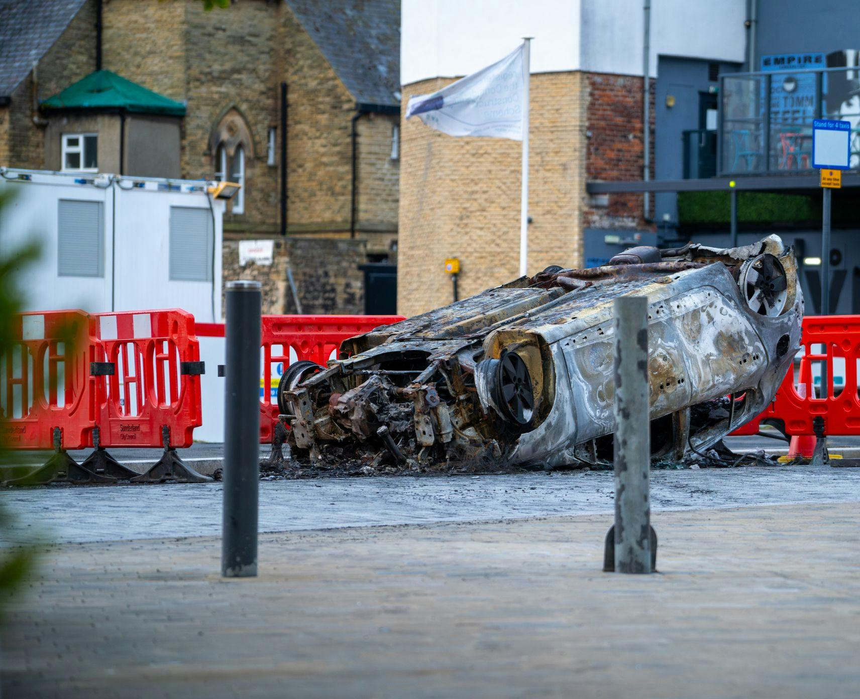 An upside down burnt car in an English street