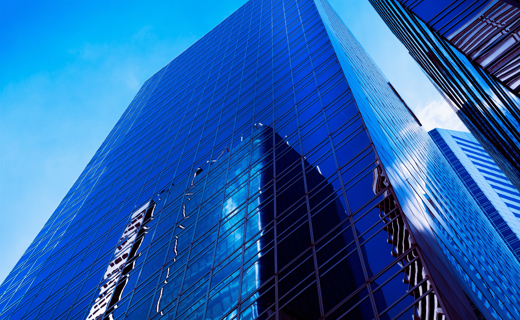 A glass skyscraper building, viewed from an upward angle.