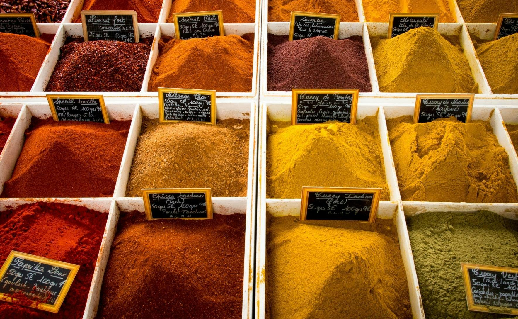 white tubs filled with red, yellow and orange ground spices in rows