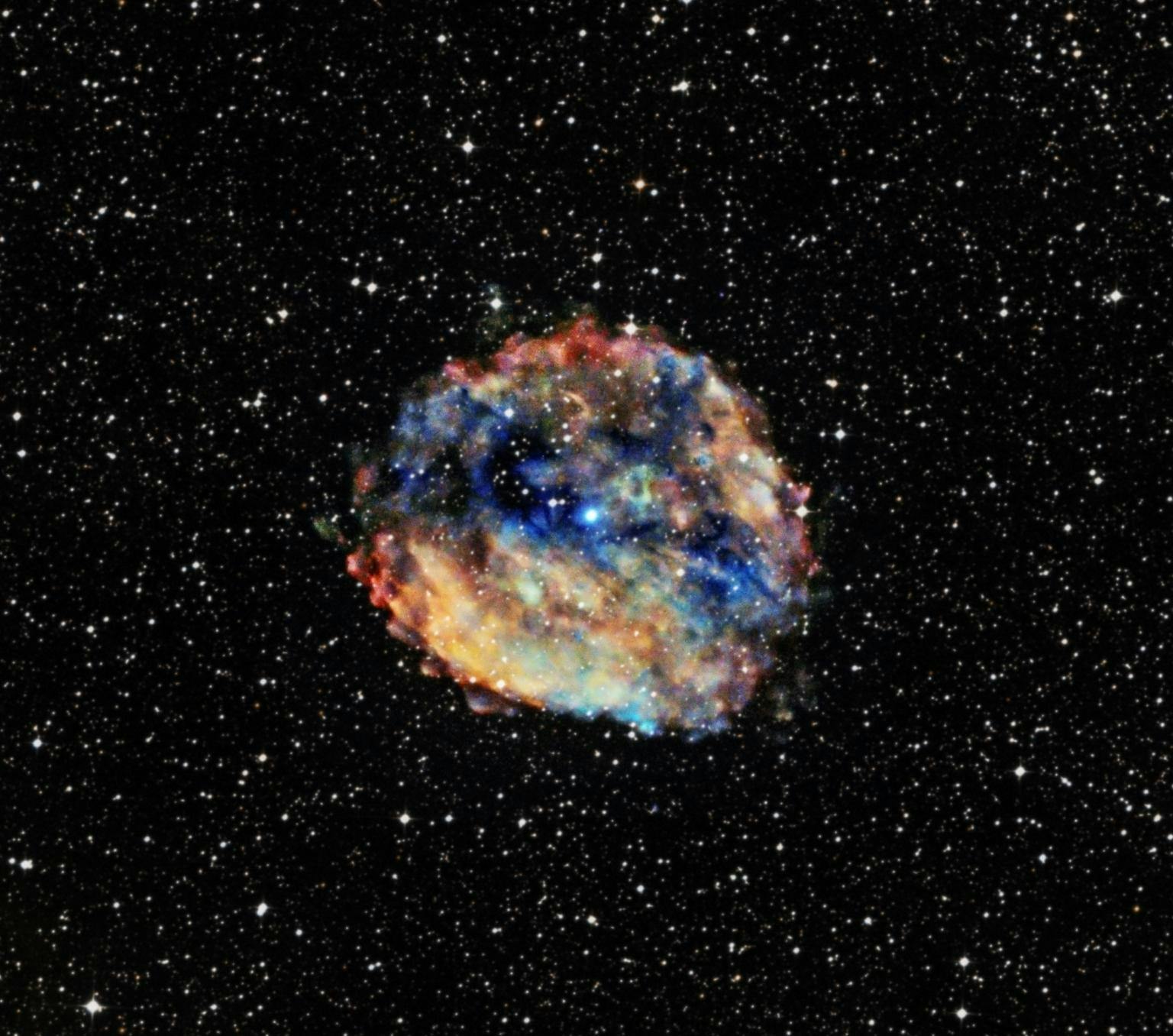 image of a cloud of colourful patche sof colour in a dark starry sky