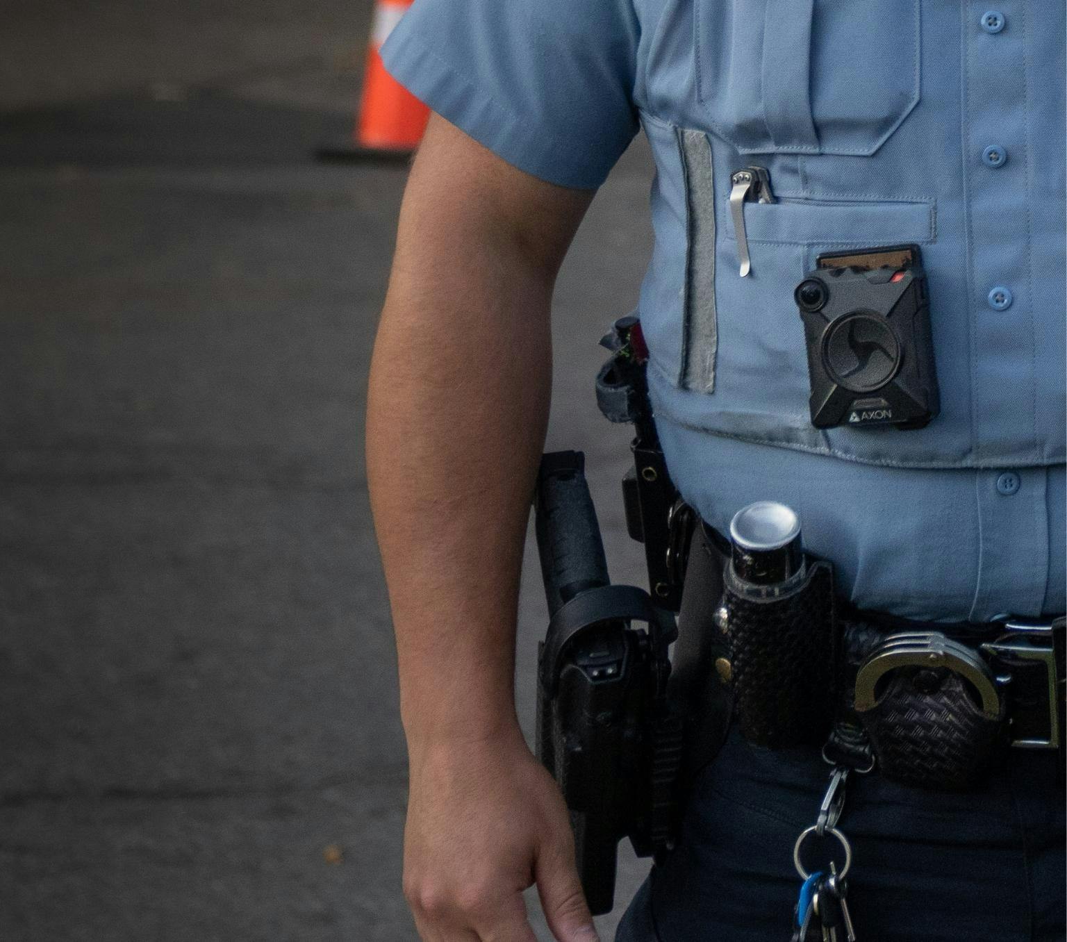 A police officer wearing a body camera. You can not identify the police officer and the image only shows from the shoulders down