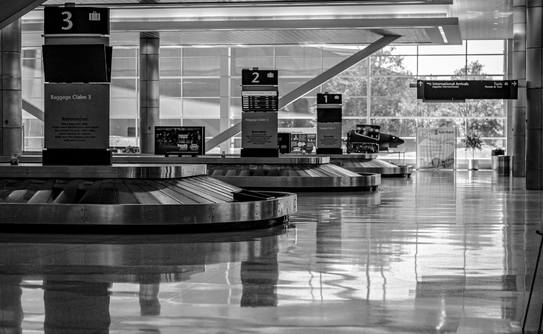 An empty baggage claims hall with empty carousels.