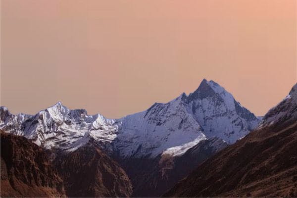 An image of snow-capped mountains with an orange background.
