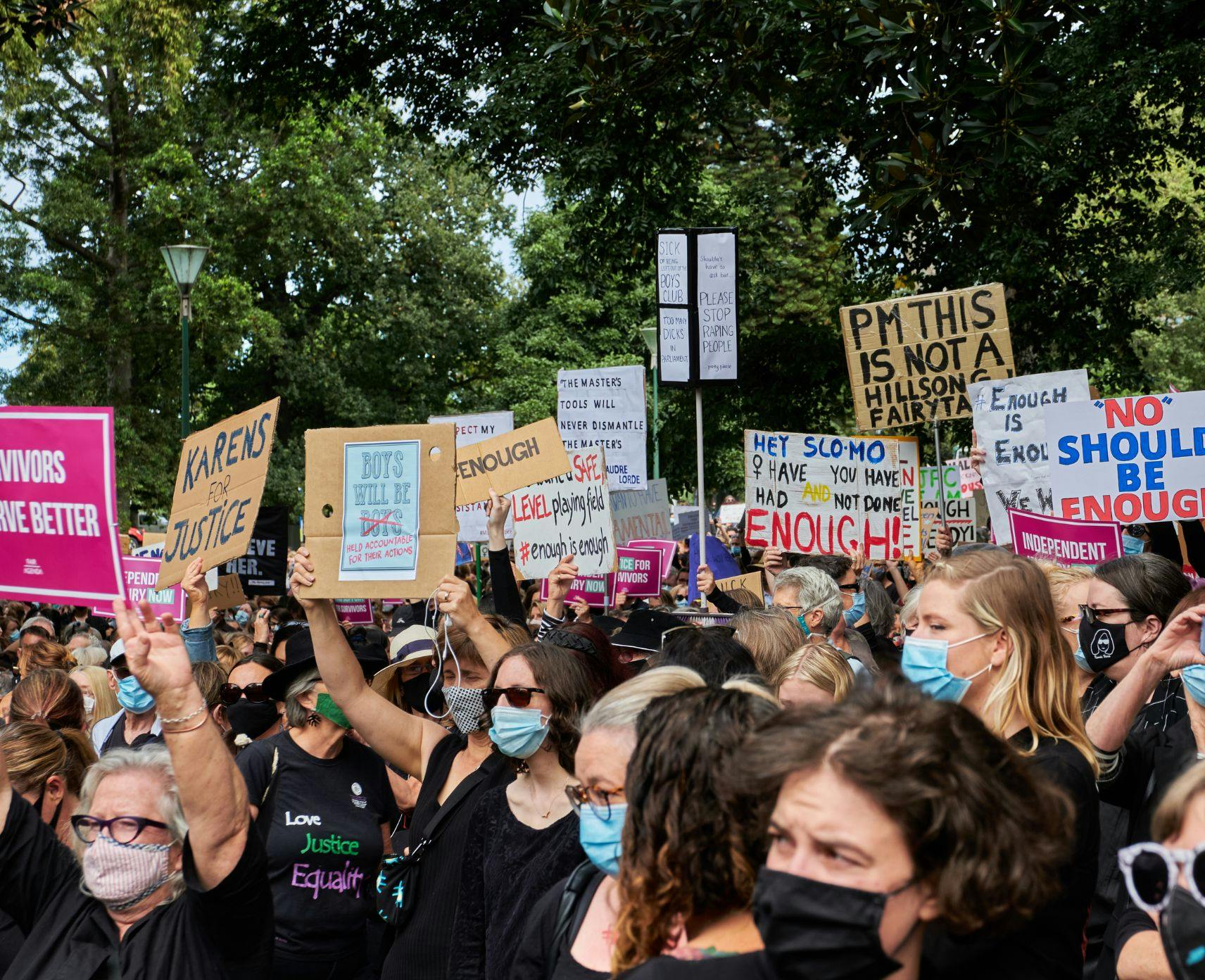 A crowd of female protesters wearing masks and holding placards at a protest in Melbourne. Everyone looks focused and determined.