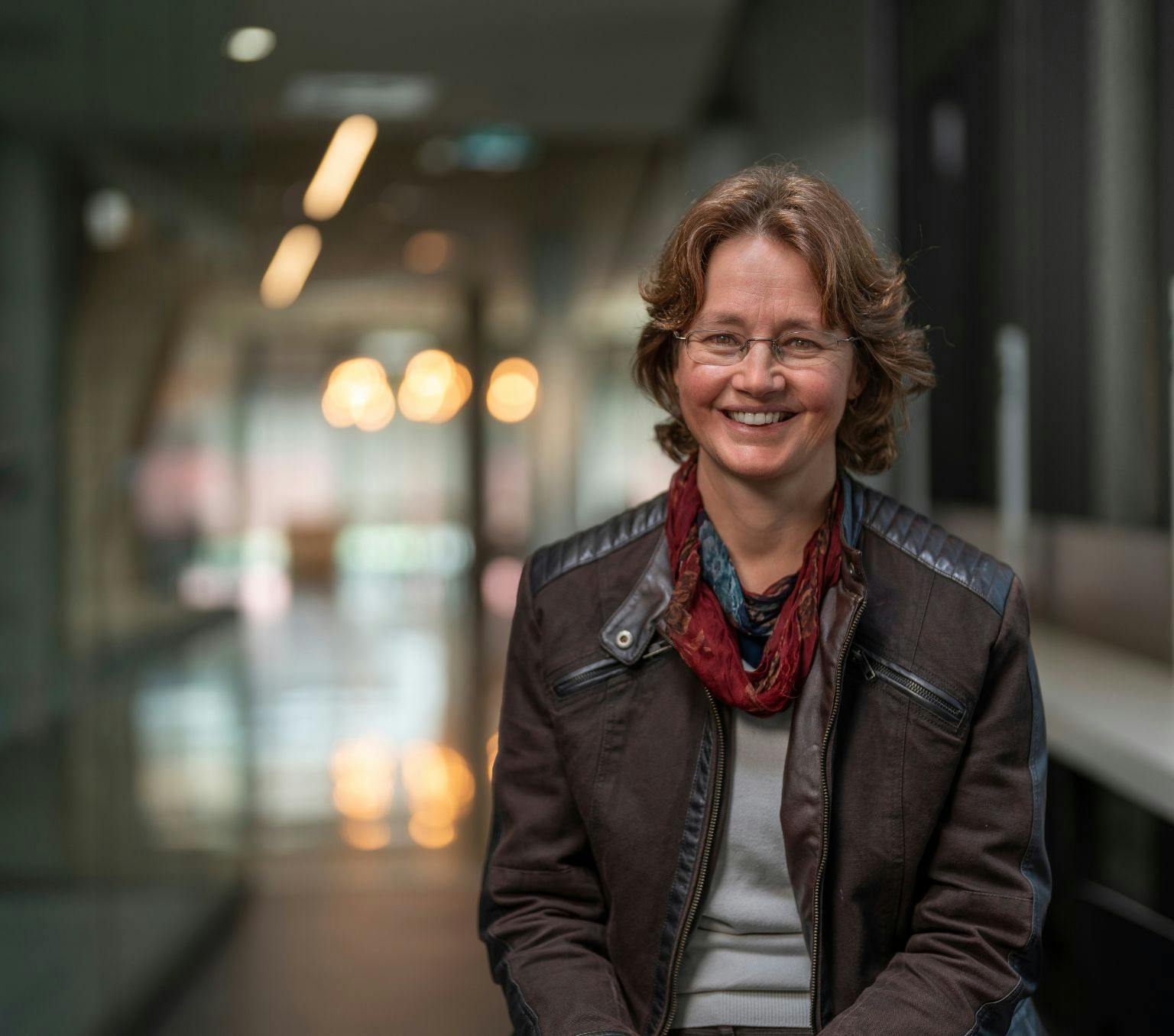 Professor Kylie Catchpole smiling and wearing a dark jacket and red necklace.