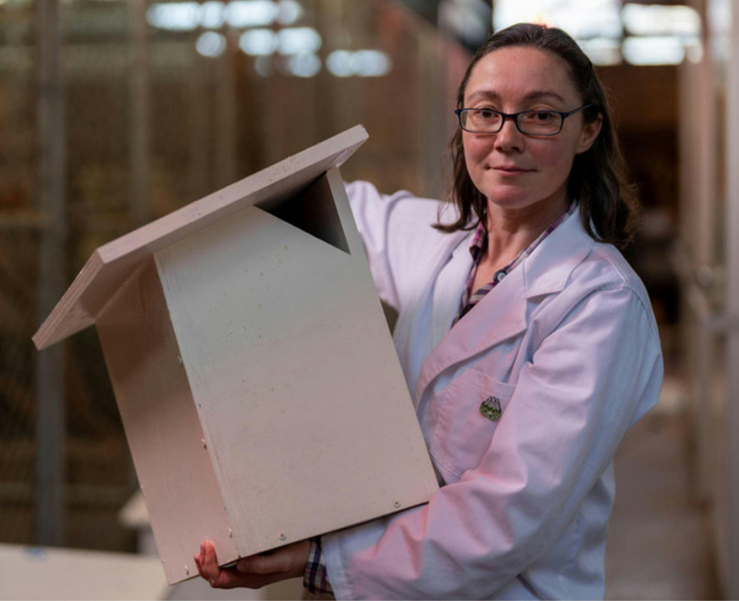 Dr Kara Youngentob holding a white hi-tech nest boxes.