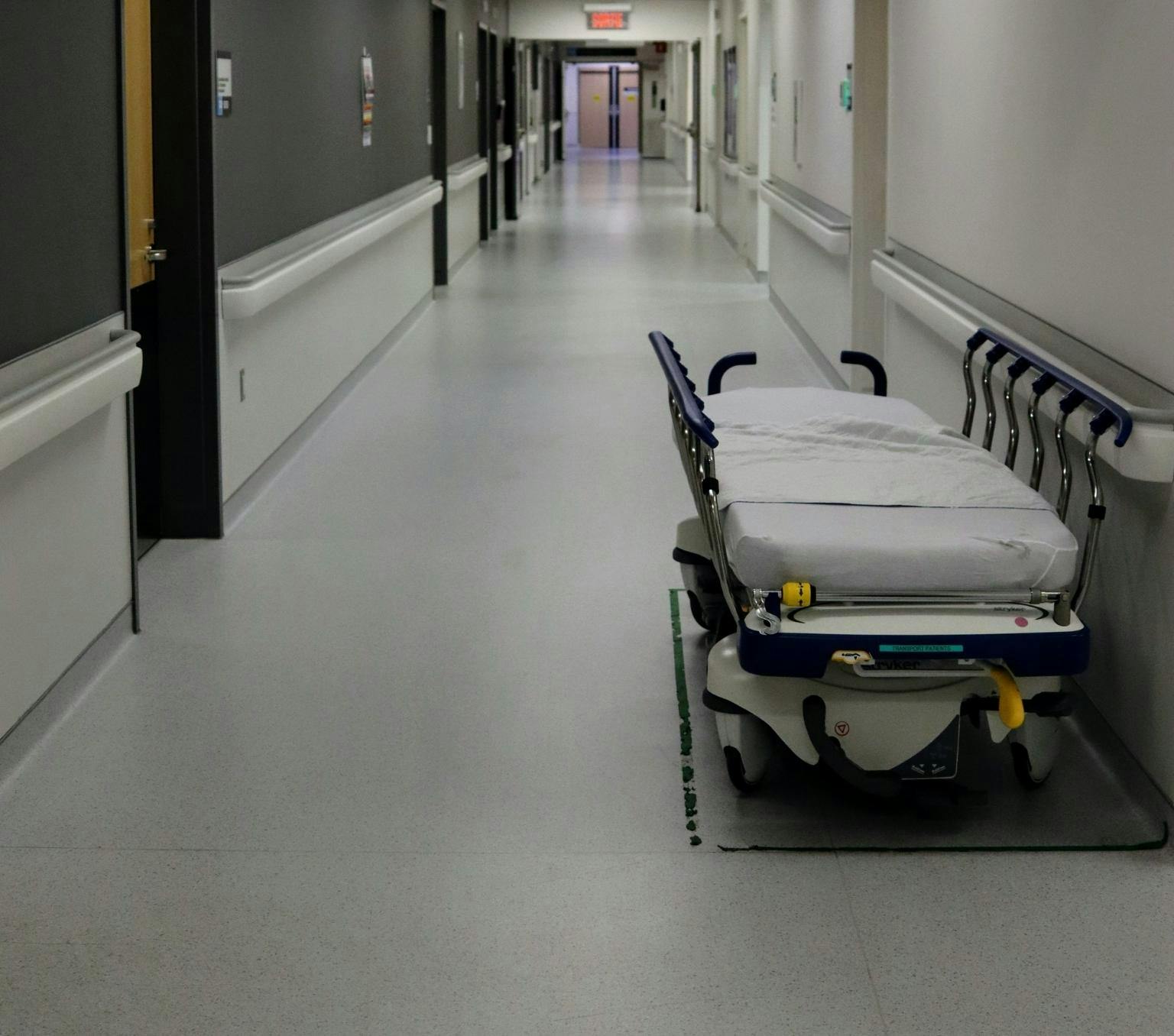 empty hospital corridor with a patient bed in the foreground