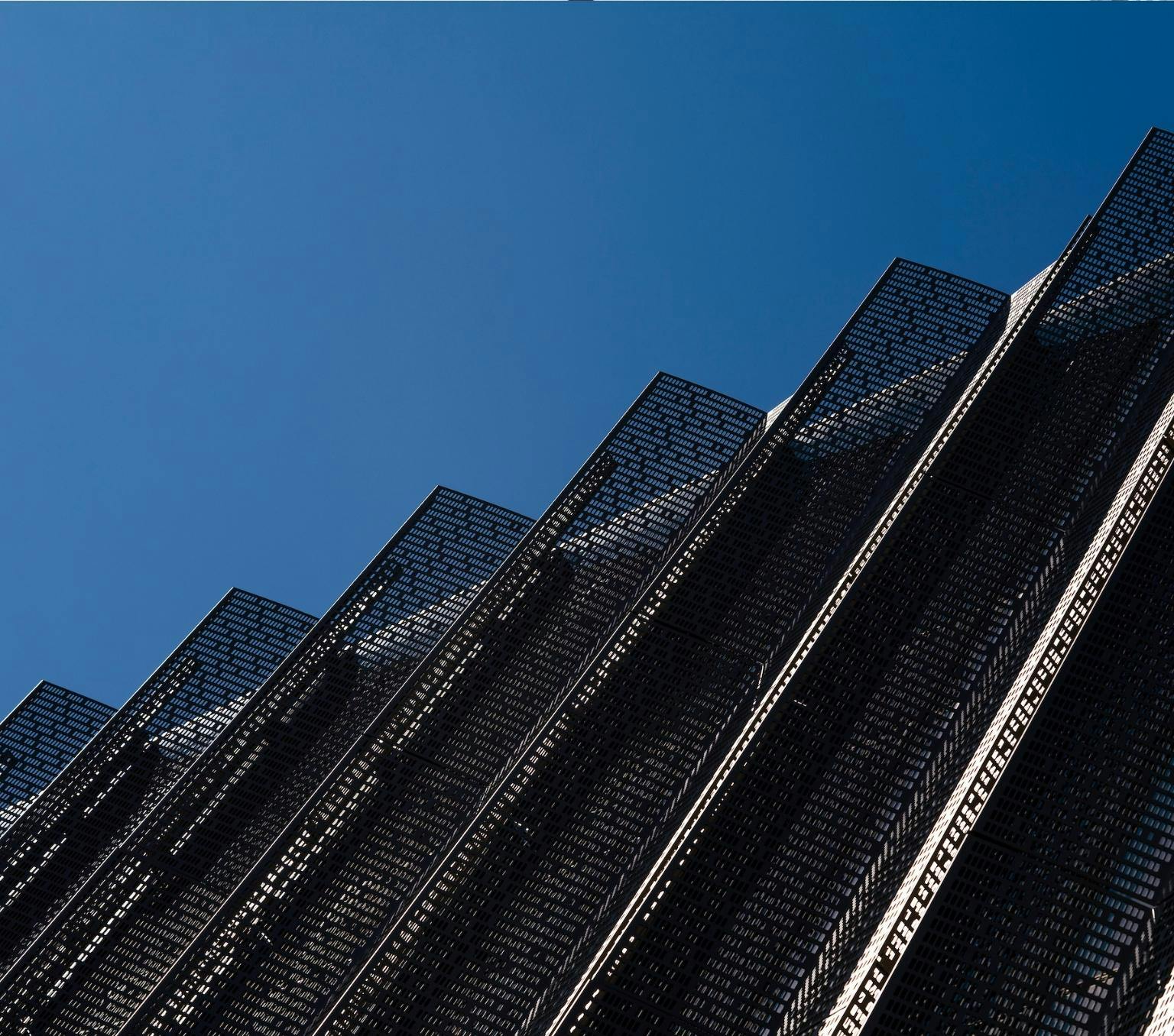 mesh panels on a building with a bright blue sky behind