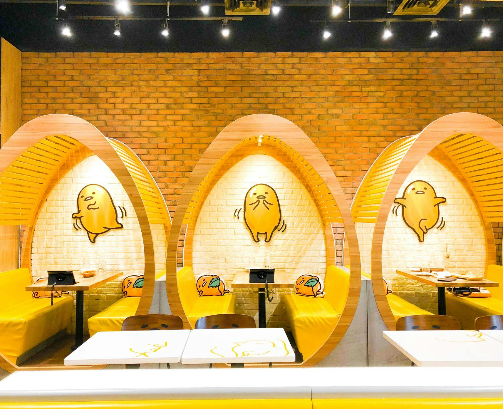 Gudetama cafe in Singapore. The booths have egg-shaped arches which all feature an illustration of Gudetama in a different pose.