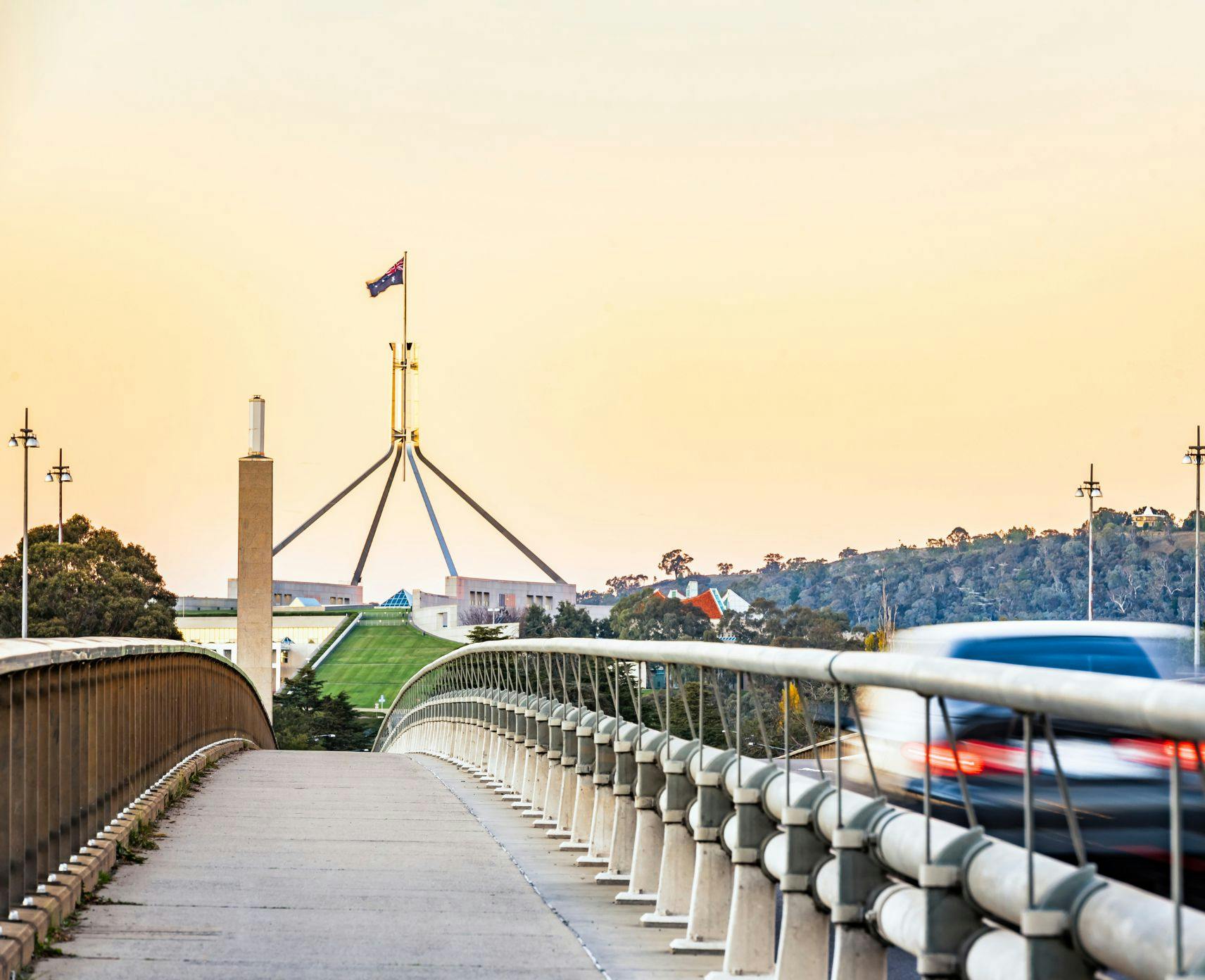 Cars driving across Canberra bridge towards Parliament House