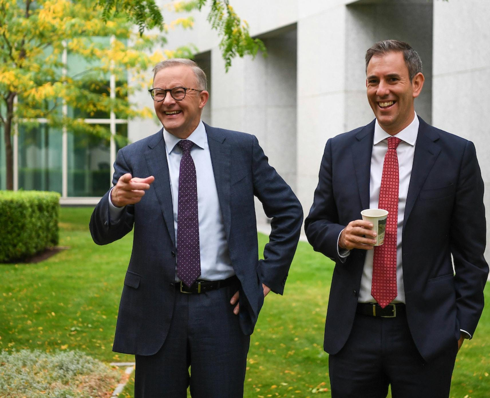 Anthony Albanese and Jim Chalmers standing and smiling in the Parliament House courtyard