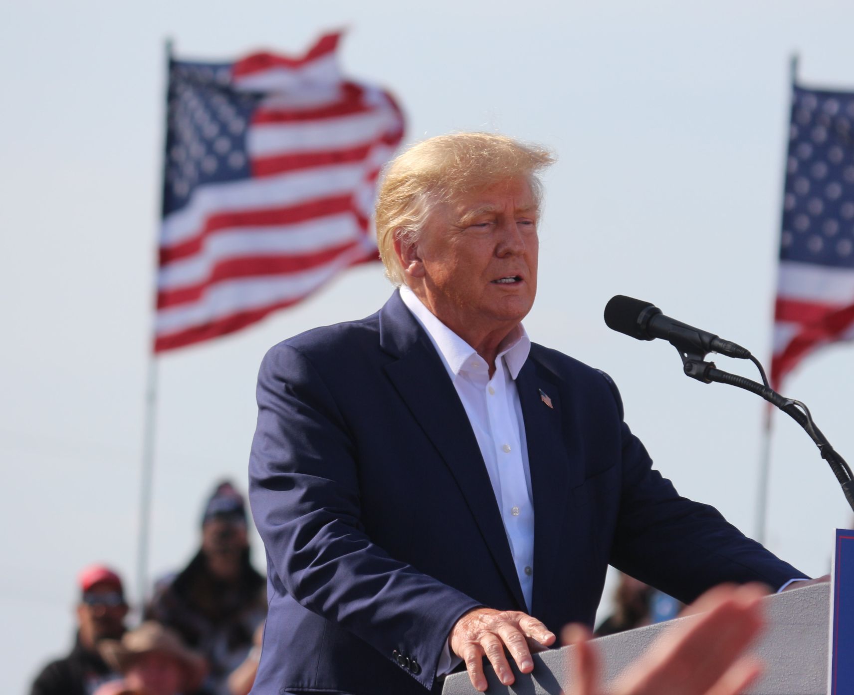 Donald Trump speaks at a political rally in 2022 in front of two American flags