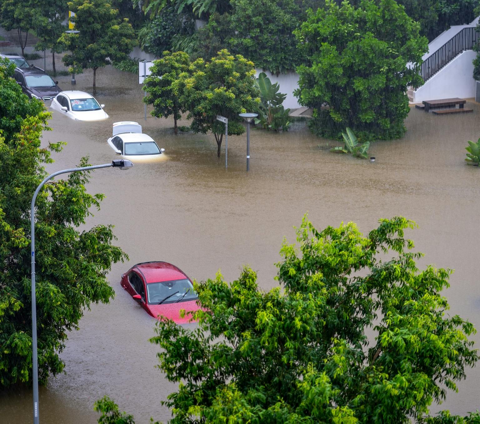 Cars under water on a suburban street due to heavy flooding