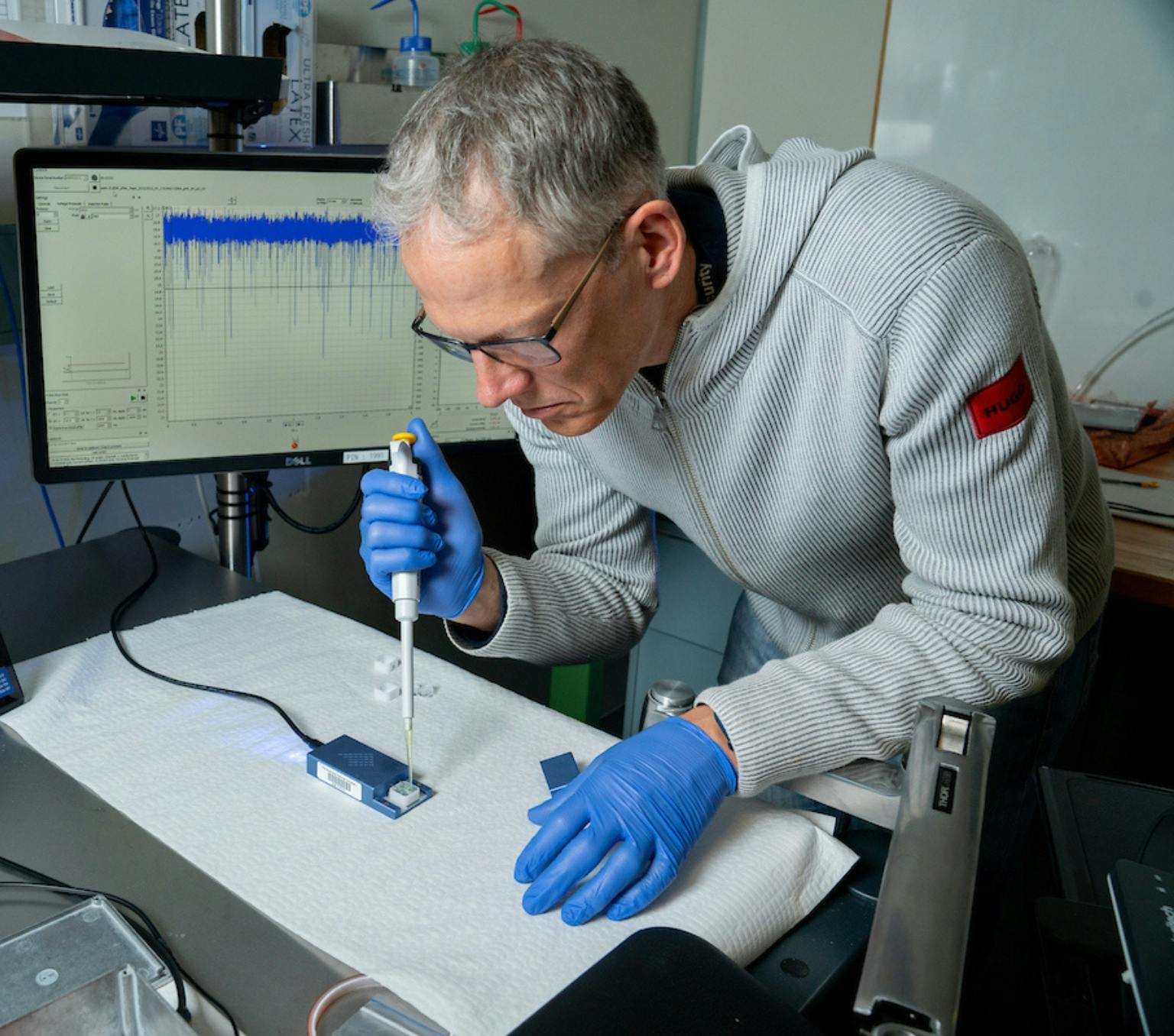 Professor Patrick Kluth injecting an unknown sample onto the new ANU technology, which is roughly the size of a mobile phone