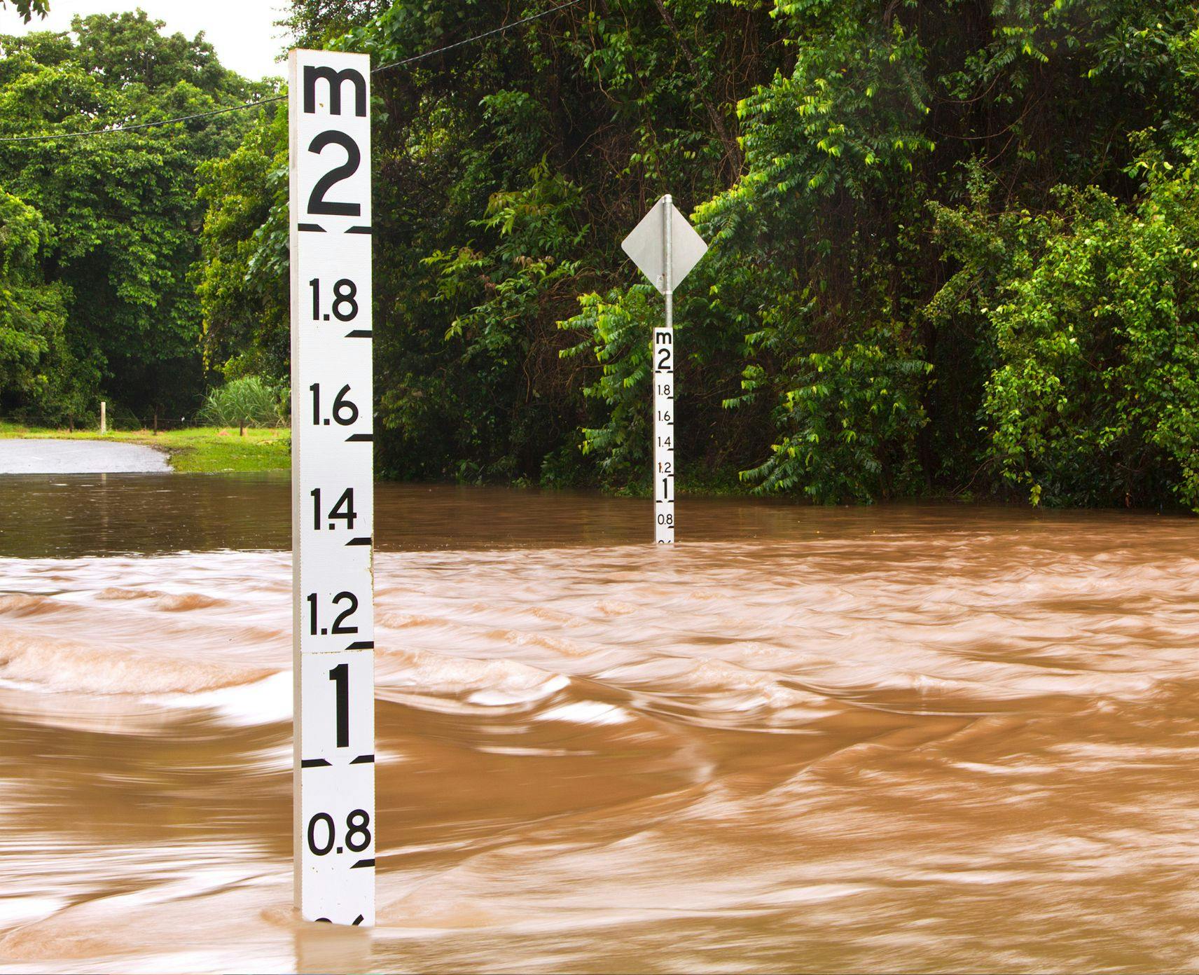 Flooded road with depth indicators in Queensland, Australia