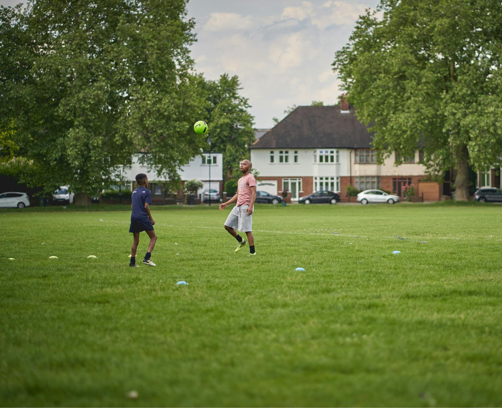 Two young men playing soccer in a park in South-East London